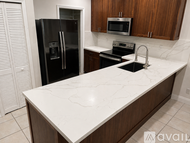 A kitchen with a black fridge and a white counter top.