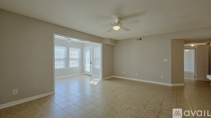 A spacious room with a ceiling fan and tile flooring.