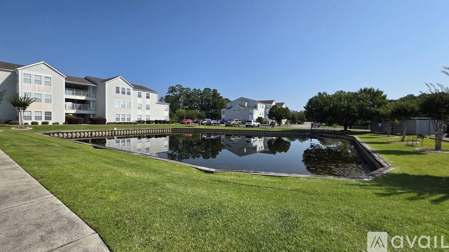 A large white building with a pool in front of it.