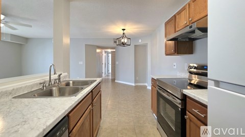 A kitchen with wooden cabinets and a marble countertop.