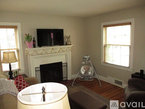 A living room with a fireplace and a television on the mantle.