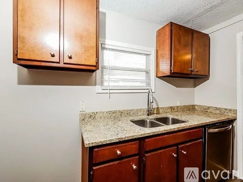 A kitchen with brown cabinets and a granite countertop.