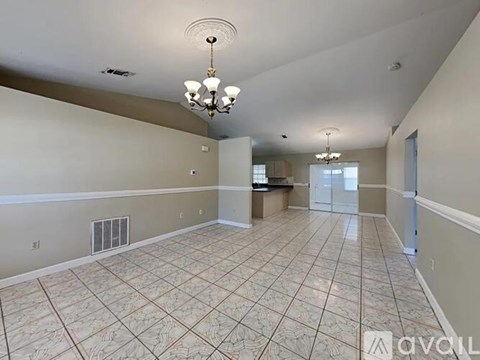 A room with beige walls and a window with blinds.