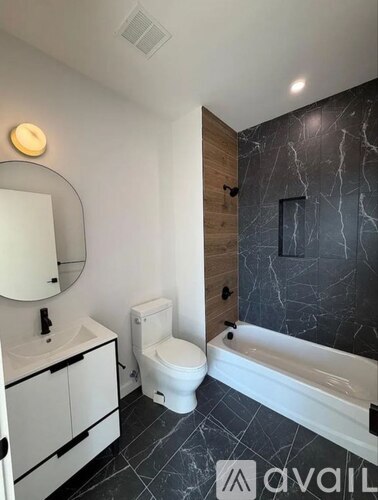 A bathroom with a marble wall and a white toilet.