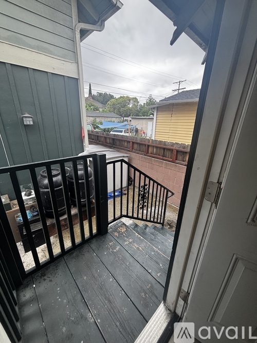 A balcony with a black railing and a view of a pool and trees.