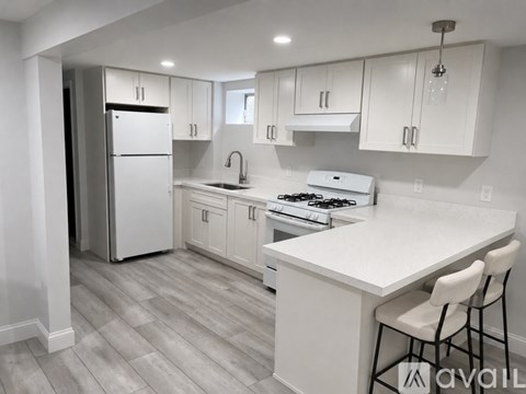 A kitchen with white cabinets and a white countertop.