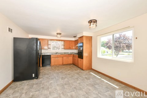A kitchen with black appliances and wooden cabinets.