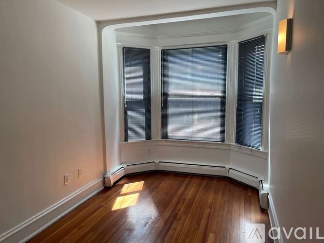 A room with a window and wooden floors.