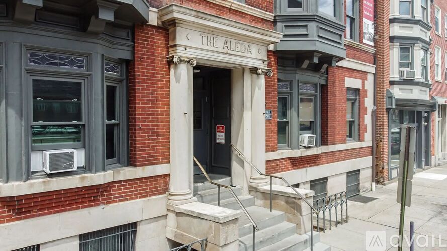 The front of a building with a red brick facade and a sign that reads "The Alley.".