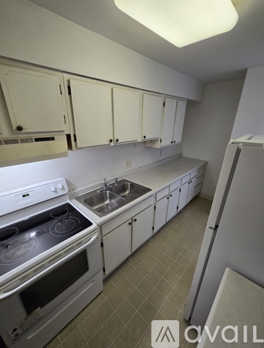 A kitchen with white appliances and cabinets.