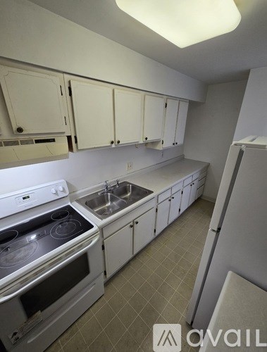 A kitchen with white appliances and cabinets.