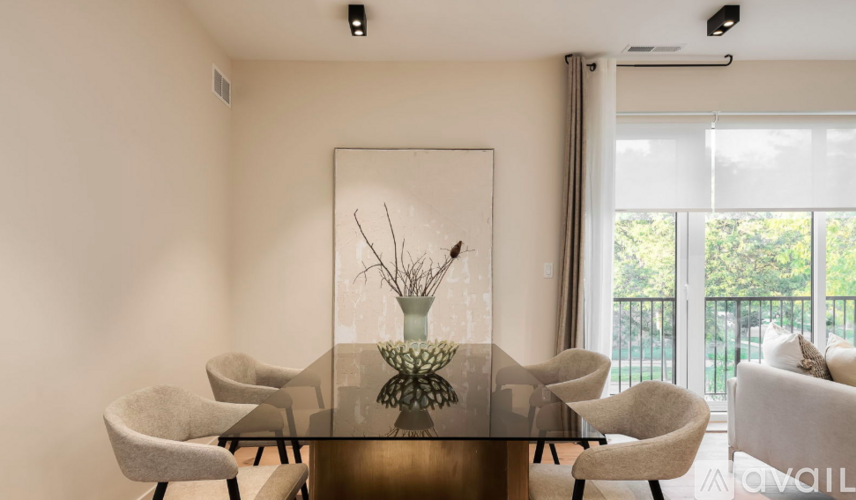A modern dining room with a glass table and chairs.