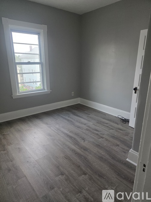 A room with a grey floor and a window.