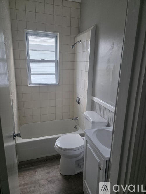 A white toilet sits next to a bathtub in a bathroom.