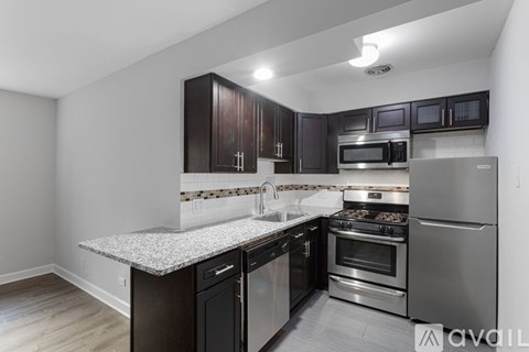 A kitchen with dark wood cabinets and stainless steel appliances.
