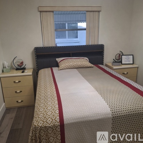 A neatly made bed with a red and white striped comforter.