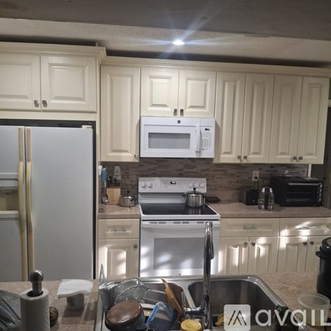 A kitchen with white cabinets and a stainless steel stove.
