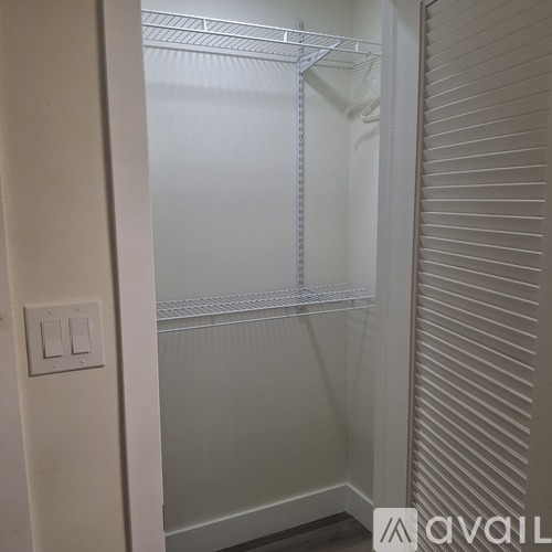 A white door with a light switch on the wall.
