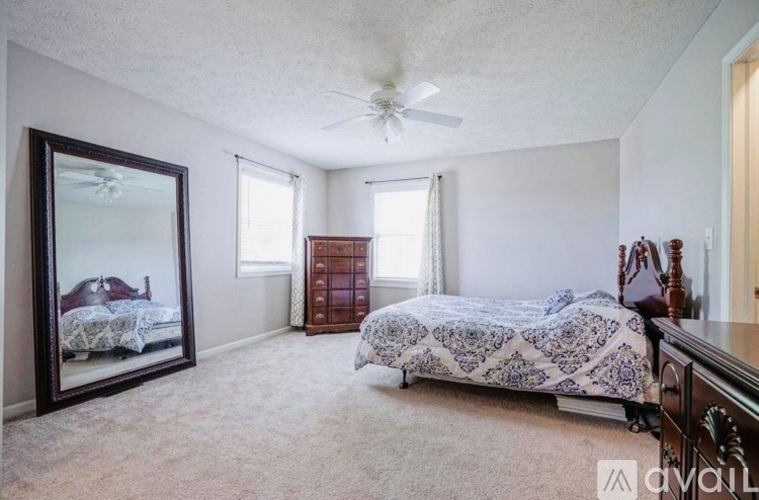 A bedroom with a large bed and a dresser.