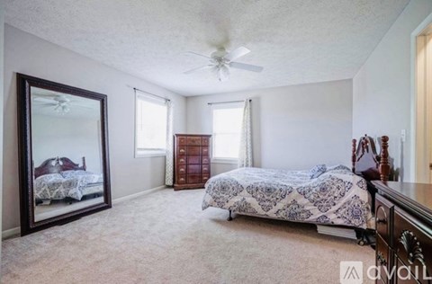 A bedroom with a large bed and a dresser.