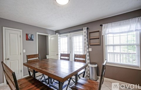 A dining room with a wooden table and chairs.