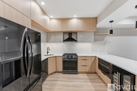 A modern kitchen with wooden cabinets and stainless steel appliances.
