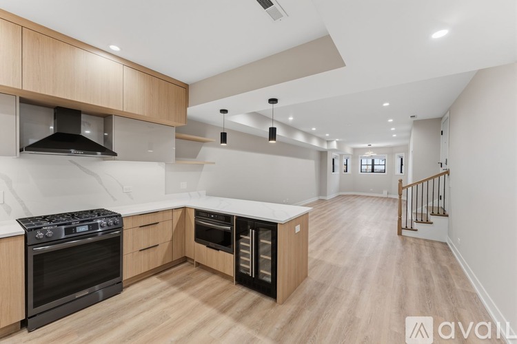 A modern kitchen with wooden cabinets and black appliances.