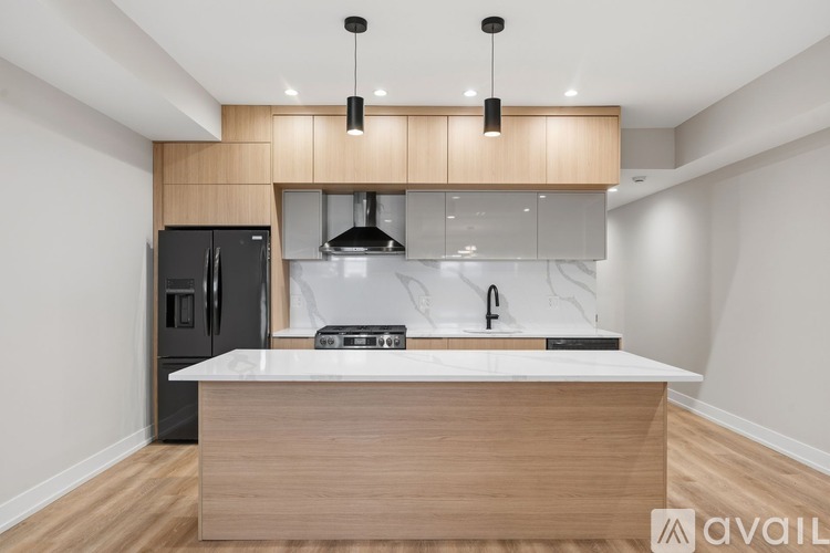 A modern kitchen with a wooden island and black appliances.