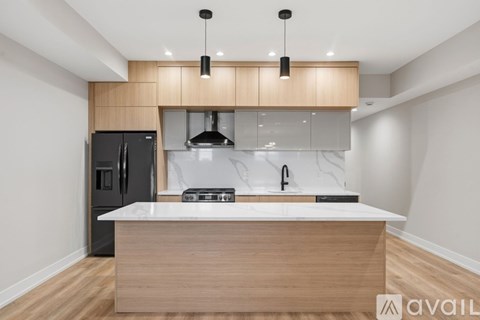 A modern kitchen with a wooden island and black appliances.