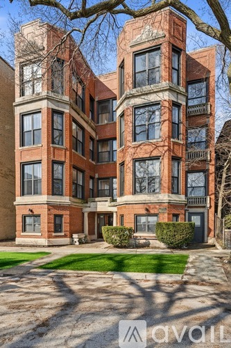 A large, multi-story building with a brick facade and multiple windows.