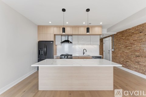 A modern kitchen with a wooden island and a brick wall.