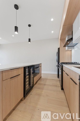 A kitchen with wooden cabinets and black appliances.