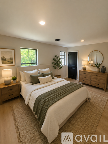 A bedroom with a large bed, a side table with a lamp, and a dresser with a mirror.