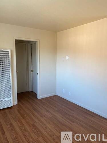 A room with wooden flooring and a closed door.