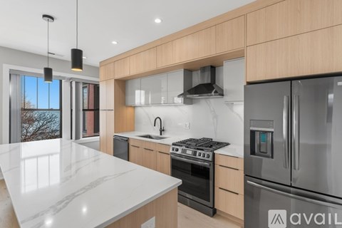 A modern kitchen with wooden cabinets and stainless steel appliances.