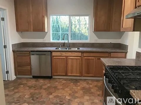 A kitchen with wooden cabinets and a granite countertop.