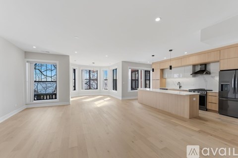 A spacious kitchen with wooden floors and modern appliances.