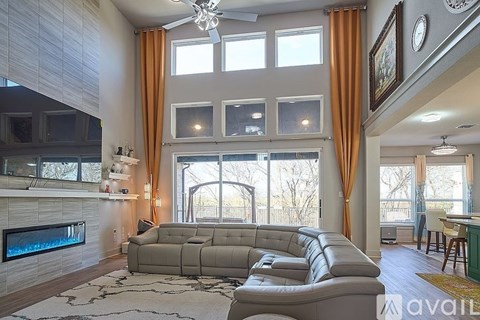 A living room with a grey sofa and a fireplace.