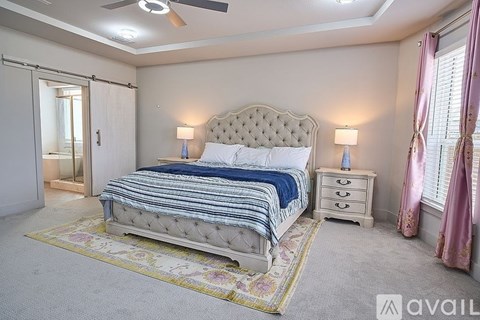 A bedroom with a large bed, a dresser, and a ceiling fan.