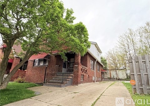 A house with a red brick exterior and a wooden fence.