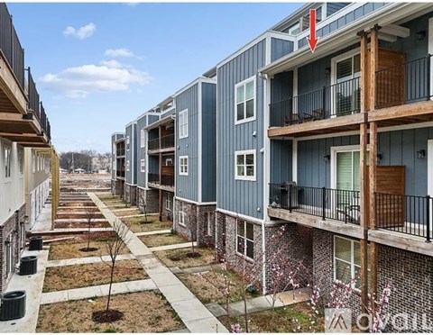 A row of townhouses with balconies and front yards.