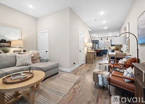 A living room with a grey couch, a wooden coffee table, and a large painting on the wall.