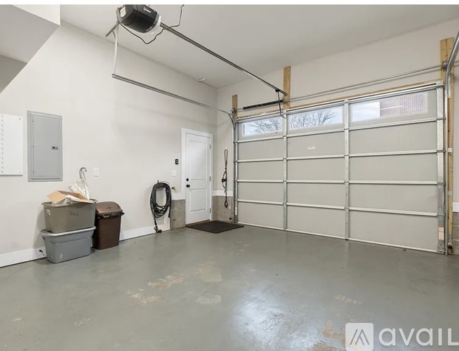 A spacious garage with a white door and a black mat on the floor.