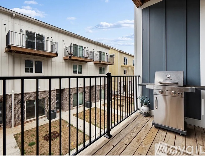A balcony with a grill and a fence in front of a building.