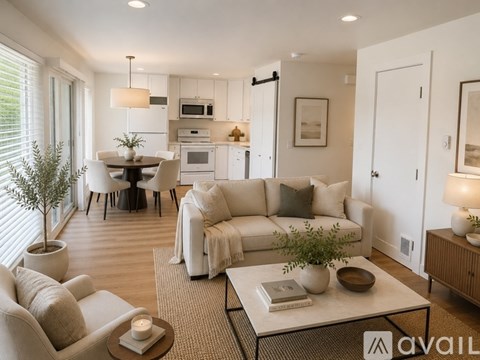 A modern living room with a dining area and kitchen in the background.
