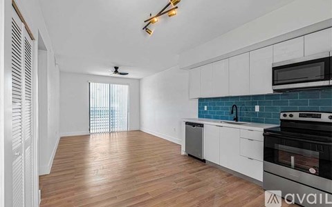 A kitchen with white cabinets and a black stove top oven.
