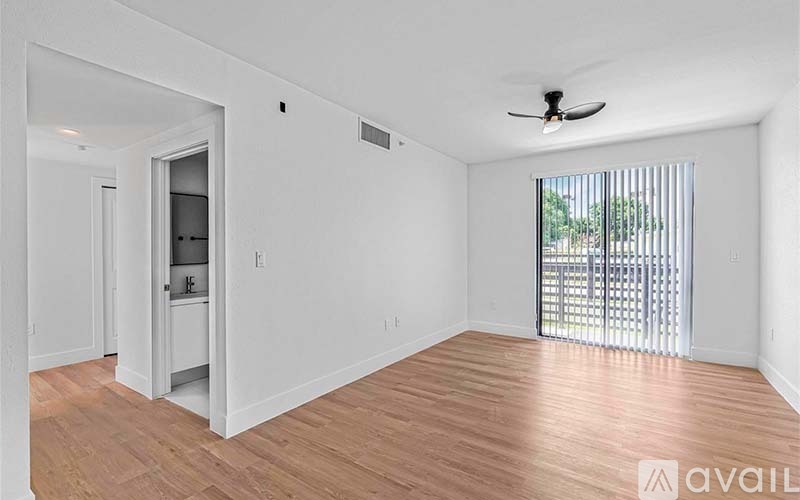 A room with a fan and a sliding glass door leading outside.