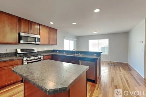 A kitchen with wooden cabinets and a granite countertop.