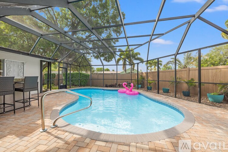 A pool with a pink flamingo float in the middle of it.