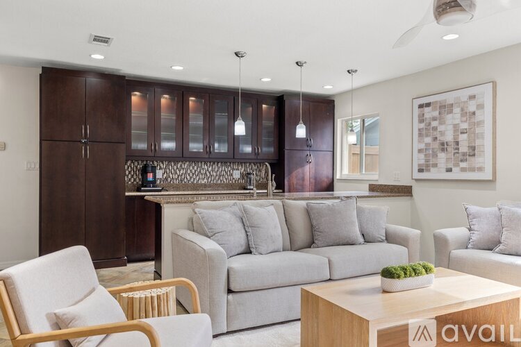 A living room with a grey couch, a wooden coffee table, and a large painting on the wall.